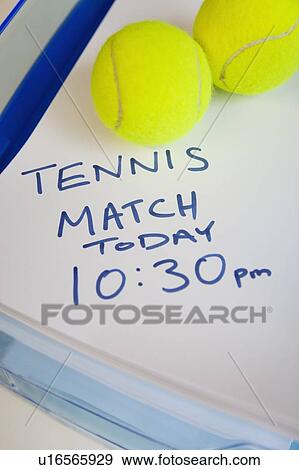 Stock Photo - Tennis balls on note indicating match timing. Fotosearch