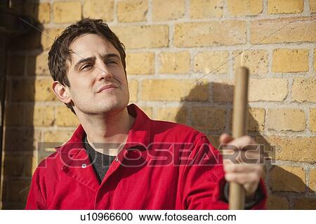 Thoughtful young male street sweeper looking away View Large Photo Image Stock Image - Thoughtful young male street sweeper looking away. Fotosearch