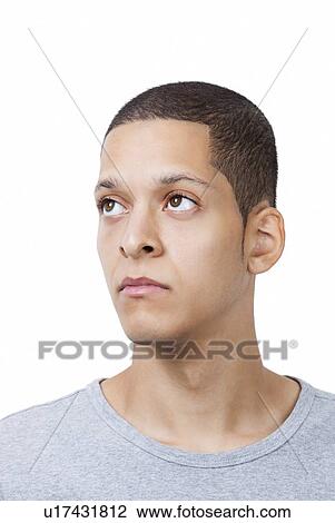 Thoughtful young man looking away against white background View Large Photo Image Stock Image - Thoughtful young man looking away against white background. Fotosearch