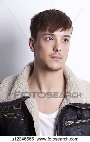 Stock Photograph - Thoughtful young man looking away against white background. Fotosearch