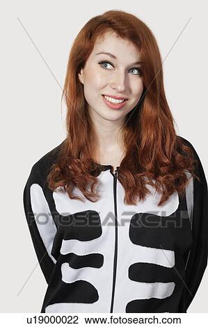 Thoughtful young woman in skeleton costume against gray background View Large Photo Image Stock Image - Thoughtful young woman in skeleton costume against gray background. Fotosearch