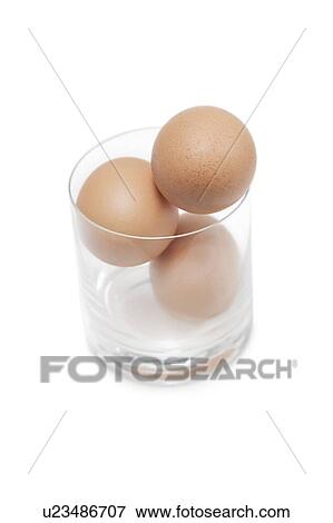 Three brown eggs in drinking glass over white background View Large Photo Image Stock Photo - Three brown eggs in drinking glass over white background. Fotosearch