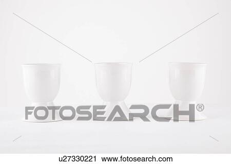 Three empty egg cups side by side over white background View Large Photo Image Stock Image - Three empty egg cups side by side over white background. Fotosearch