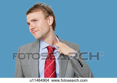 Picture - Tired young businessman loosening tie. Fotosearch