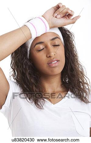 Tired young woman with hand on head against white background View Large Photo Image Stock Image - Tired young woman with hand on head against white background. Fotosearch