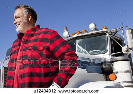 Trucker standing in front of Cargo truck View Large Photo Image Stock Image - Trucker standing in front of Cargo truck. Fotosearch