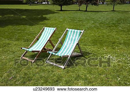 Two deck chairs in a park View Large Photo Image Stock Image - Two deck chairs in a park. Fotosearch