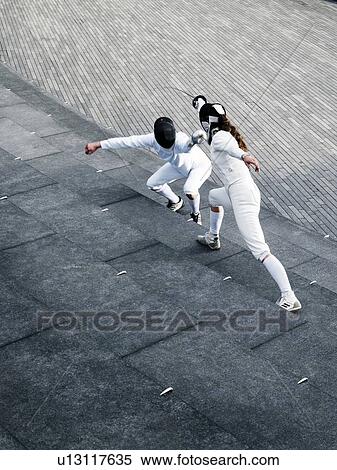 Two fencers fencing outside together View Large Photo Image Stock Photography - Two fencers fencing outside together. Fotosearch