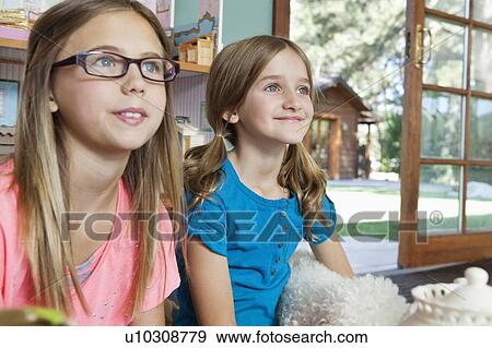 Two young sisters watching television View Large Photo Image Stock Photo - Two young sisters watching television. Fotosearch