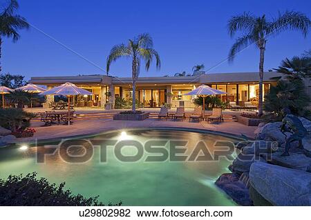 view across a pool to patio of luxury home View Large Photo Image Stock Image - view across a pool to patio of luxury home. Fotosearch