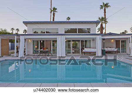 Stock Image - view across a pool to patio of luxury home. Fotosearch