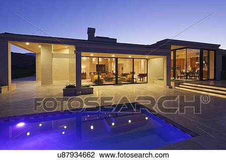 View inside modern home with swimming pool at dusk View Large Photo Image Stock Image - View inside modern home with swimming pool at dusk. Fotosearch
