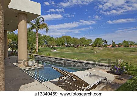 Stock Photo - View of lawn from swimming pool in luxury mansion. Fotosearch