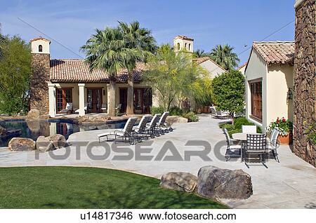 Stock Photograph - View of luxury mansion with swimming pool. Fotosearch