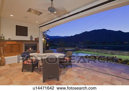 Stock Image - View of mountains and swimming pool from patio of luxury manor house. Fotosearch