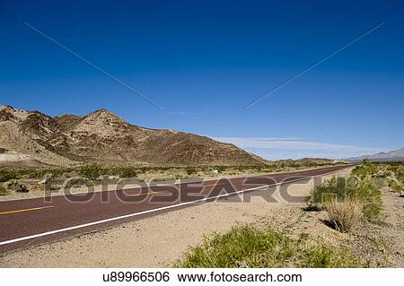Stock Photograph - View of remote Kelbaker Road below clear blue sky. Fotosearch