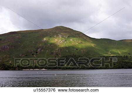 View of sea against mountain against cloudy sky View Large Photo Image Stock Photograph - View of sea against mountain against cloudy sky. Fotosearch
