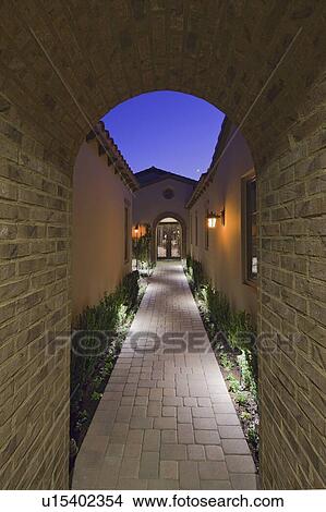 View through archway down path to French doors at dusk View Large Photo Image Picture - View through archway down path to French doors at dusk. Fotosearch