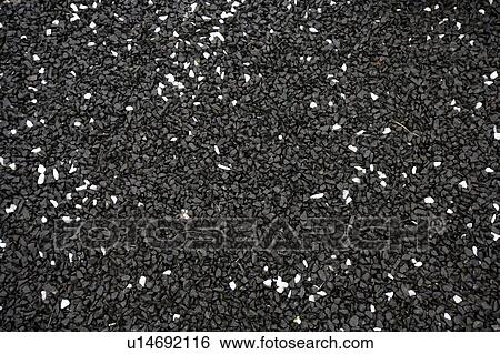 Stock Photograph - Wet black gravel with some white pebbles. Fotosearch