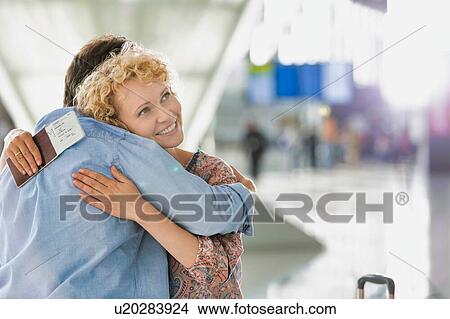 Wife reuniting with his husband in airport View Large Photo Image Picture - Wife reuniting with his husband in airport. Fotosearch