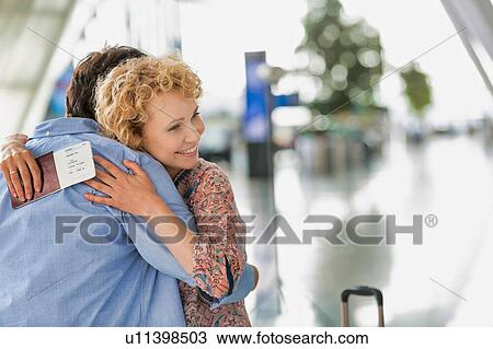 Wife reuniting with his husband in airport View Large Photo Image Stock Image - Wife reuniting with his husband in airport. Fotosearch