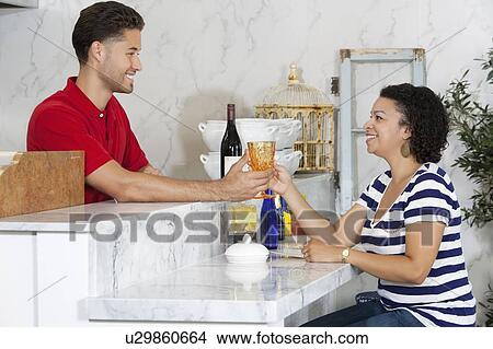 Woman handing over empty glass to male waiter at counter View Large Photo Image Picture - Woman handing over empty glass to male waiter at counter. Fotosearch