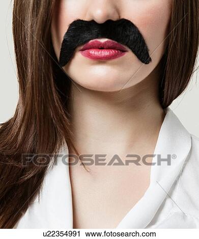 Stock Image - Woman wearing fake moustache. Fotosearch
