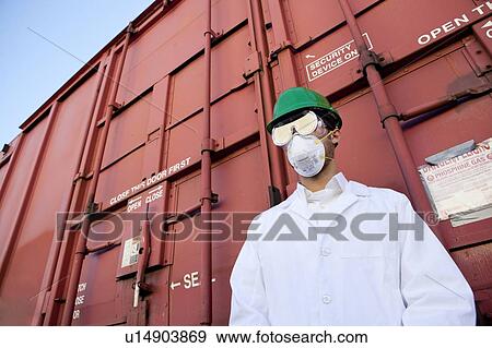 Stock Photo - Worker in hazmat suit, hard-hat and face mask. Fotosearch
