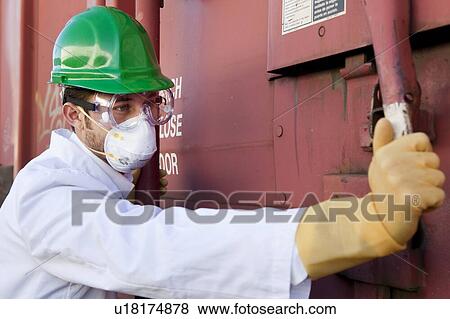 Worker in hazmat suit, hard-hat and face mask closing metal door View Large Photo Image Stock Photo - Worker in hazmat suit, hard-hat and face mask closing metal door. Fotosearch