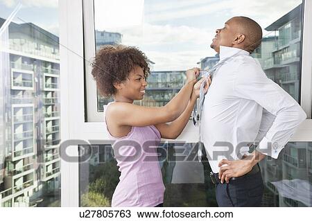 Young African American woman adjusting man's tie View Large Photo Image Stock Image - Young African American woman adjusting man's tie. Fotosearch