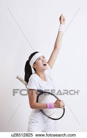 Young Asian female tennis player celebrating her success against white background View Large Photo Image Stock Photography - Young Asian female tennis player celebrating her success against white background. Fotosearch