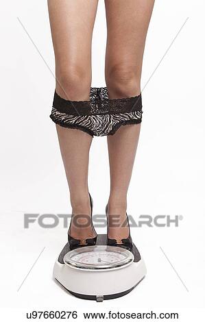 Young Asian woman in sexy lingerie standing on weight scale against white background View Large Photo Image Stock Photograph - Young Asian woman in sexy lingerie standing on weight scale against white background. Fotosearch