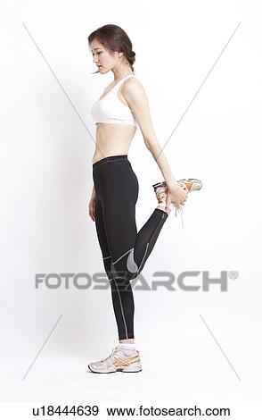 Stock Photo - Young Asian woman in stretching against white background. Fotosearch