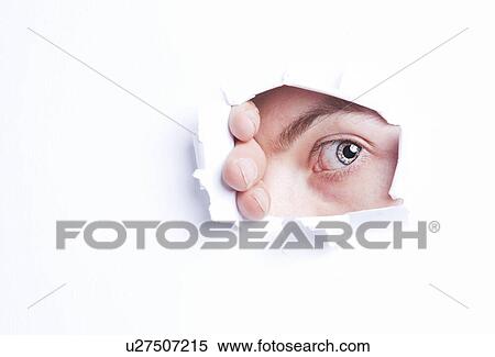 Stock Photography - Young Asian woman peeking from ripped paper hole. Fotosearch