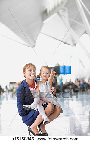 Stock Photograph - Young attractive airport staff talking to cute little girl in airport. Fotosearch