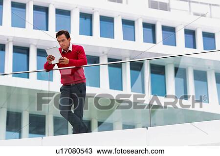 Stock Image - Young attractive businessman using digital tablet. Fotosearch