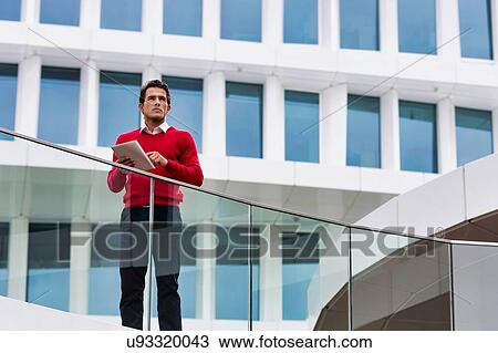 Stock Image - Young attractive businessman using digital tablet. Fotosearch