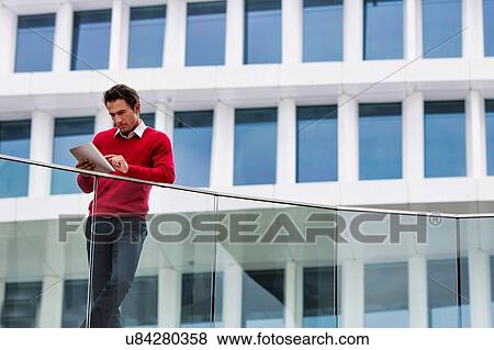 Young attractive businessman using digital tablet View Large Photo Image Stock Photo - Young attractive businessman using digital tablet. Fotosearch