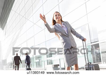 Young attractive businesswoman calling for taxi in airport View Large Photo Image Stock Photo - Young attractive businesswoman calling for taxi in airport. Fotosearch
