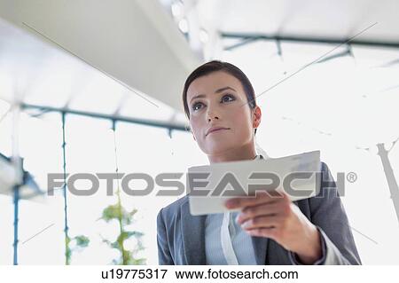 Young attractive businesswoman holding her boarding pass in airport View Large Photo Image Stock Photo - Young attractive businesswoman holding her boarding pass in airport. Fotosearch