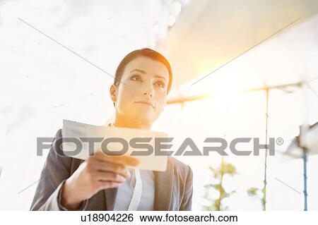 Young attractive businesswoman holding her boarding pass in airport View Large Photo Image Stock Photograph - Young attractive businesswoman holding her boarding pass in airport. Fotosearch