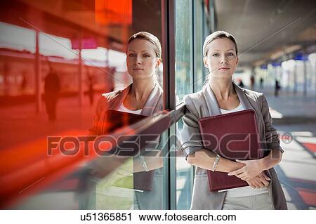 Young attractive businesswoman standing while holding document View Large Photo Image Stock Image - Young attractive businesswoman standing while holding document . Fotosearch