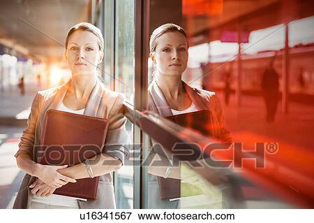Young attractive businesswoman standing while holding document View Large Photo Image Stock Photo - Young attractive businesswoman standing while holding document . Fotosearch
