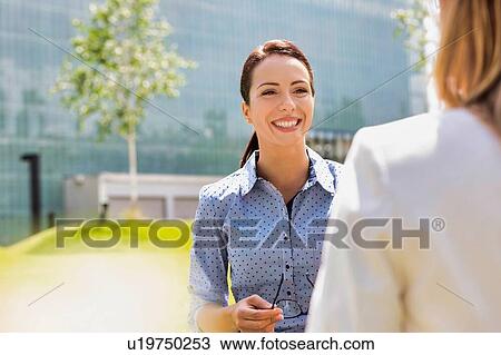 Young attractive businesswoman talking to her colleague View Large Photo Image Stock Image - Young attractive businesswoman talking to her colleague. Fotosearch