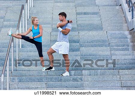 Stock Image - Young attractive couple exercising in stairs. Fotosearch