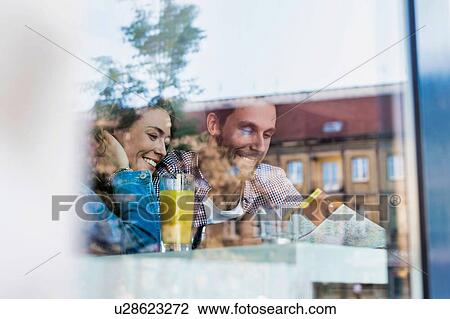 Young attractive couple smiling while looking at the menu in restaurant View Large Photo Image Stock Image - Young attractive couple smiling while looking at the menu in restaurant . Fotosearch