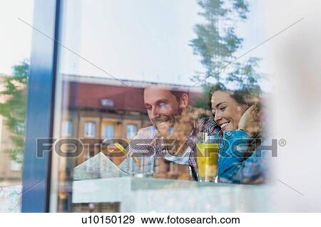 Young attractive couple smiling while looking at the menu in restaurant View Large Photo Image Stock Photo - Young attractive couple smiling while looking at the menu in restaurant. Fotosearch