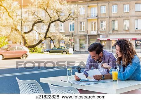 Young attractive couple smiling while looking at the menu in restaurant View Large Photo Image Stock Photo - Young attractive couple smiling while looking at the menu in restaurant. Fotosearch
