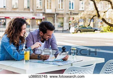 Stock Photography - Young attractive couple smiling while looking at the menu in restaurant . Fotosearch
