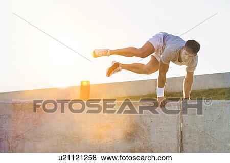 Young attractive man jumping on wall View Large Photo Image Stock Photo - Young attractive man jumping on wall. Fotosearch